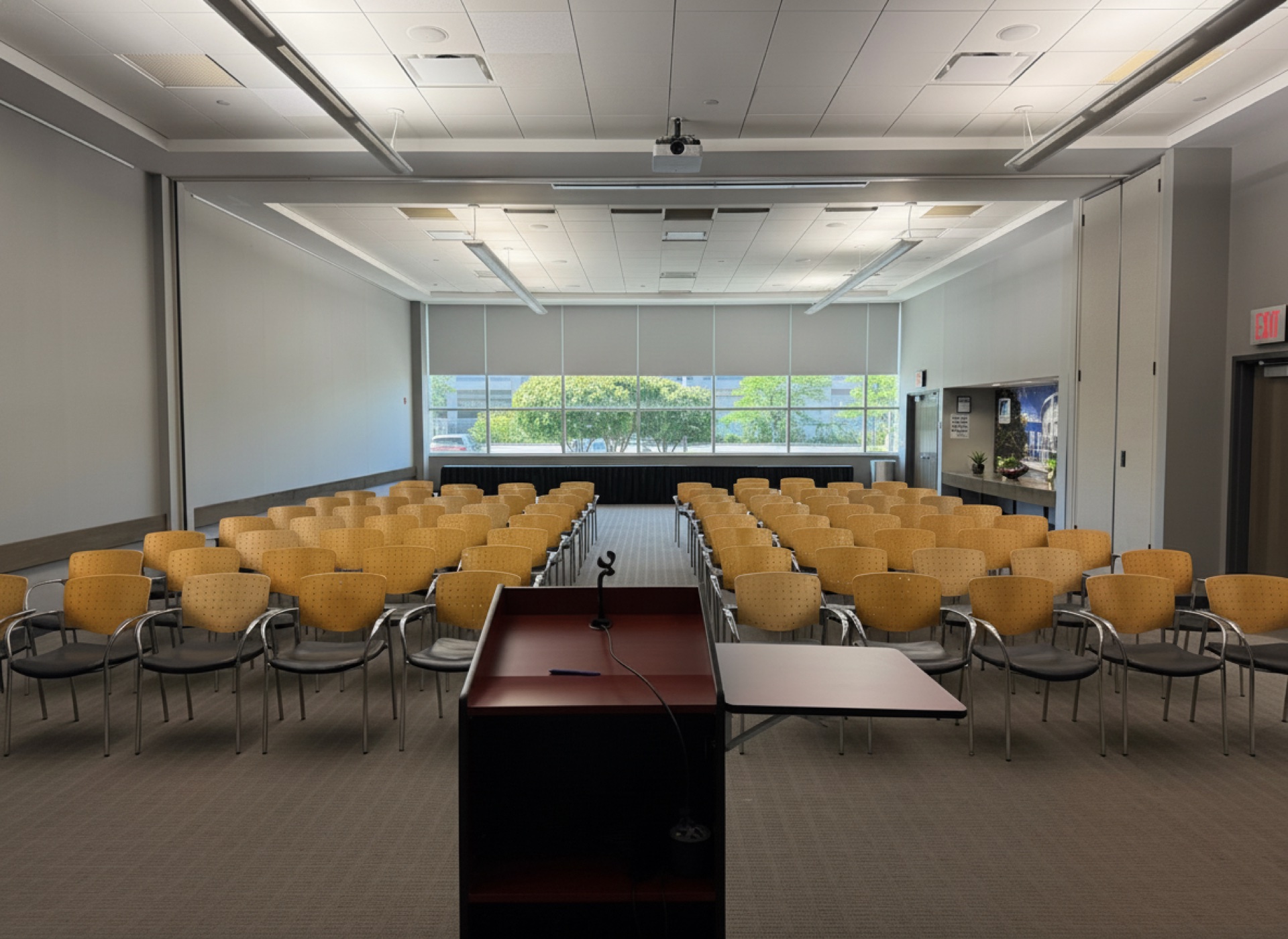 A classroom facing a podium and screen